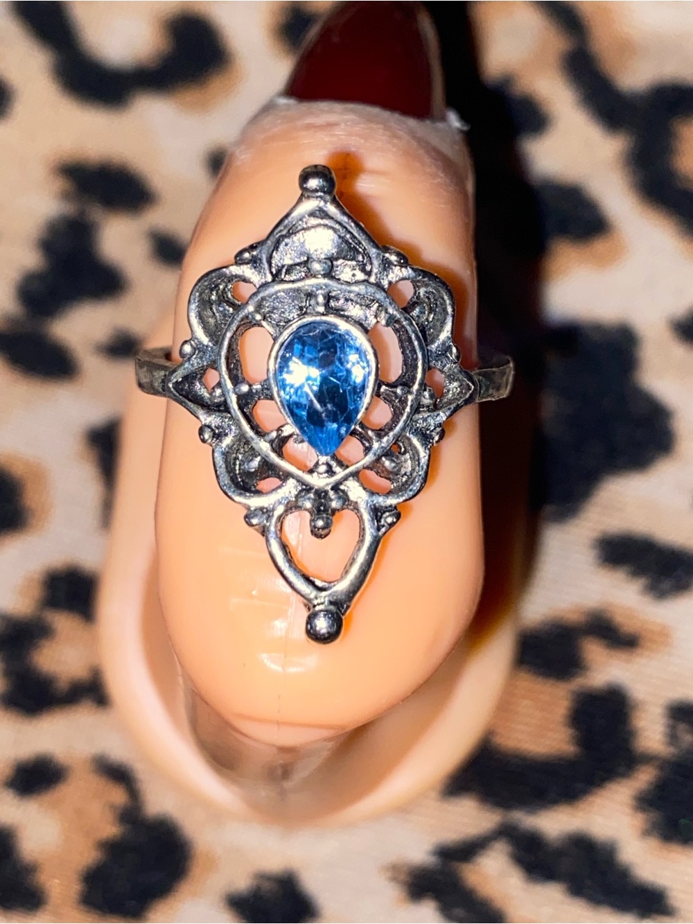 Blue gemstone ring with ornate silver filigree design
